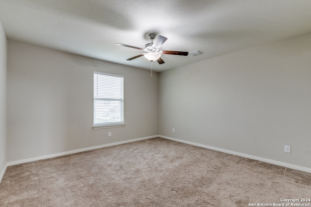 carpeted empty room with ceiling fan and a textured ceiling