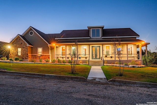 view of front of property featuring a porch and a lawn