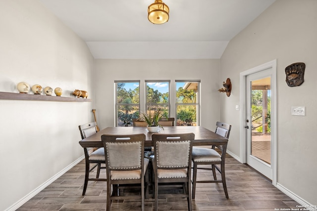 dining area with lofted ceiling, a wealth of natural light, and dark hardwood / wood-style floors