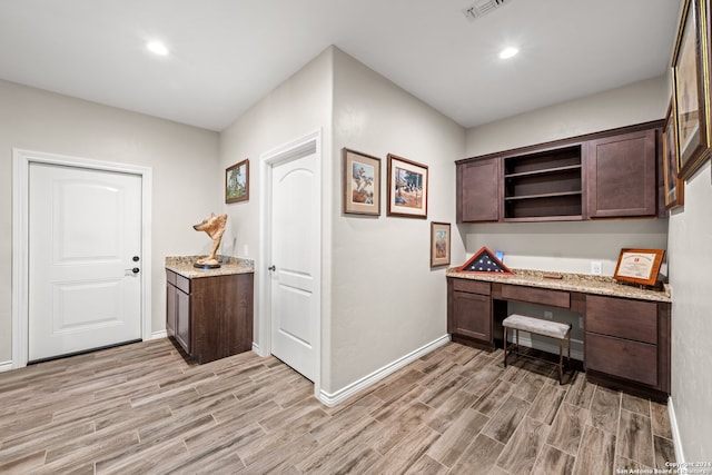 office featuring light hardwood / wood-style floors and built in desk