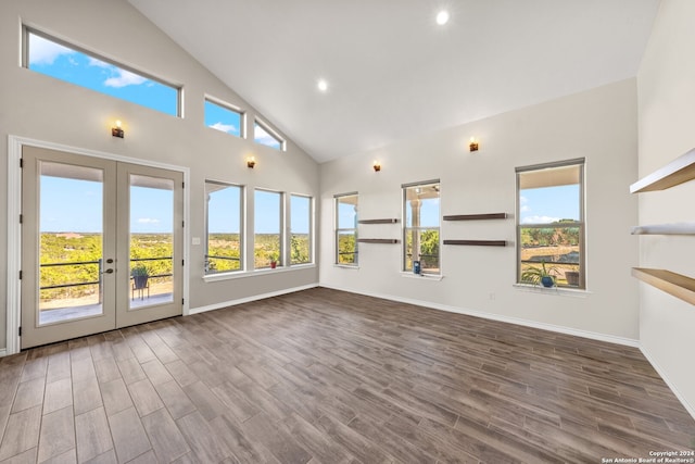 unfurnished living room featuring french doors, dark hardwood / wood-style flooring, high vaulted ceiling, and plenty of natural light