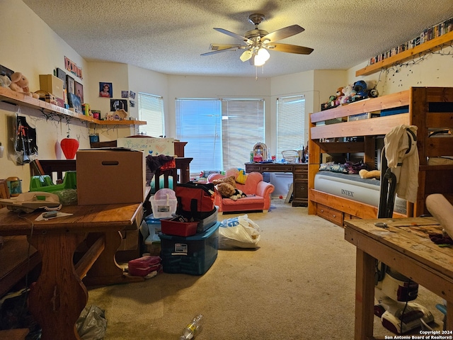 bedroom featuring carpet, ceiling fan, and a textured ceiling