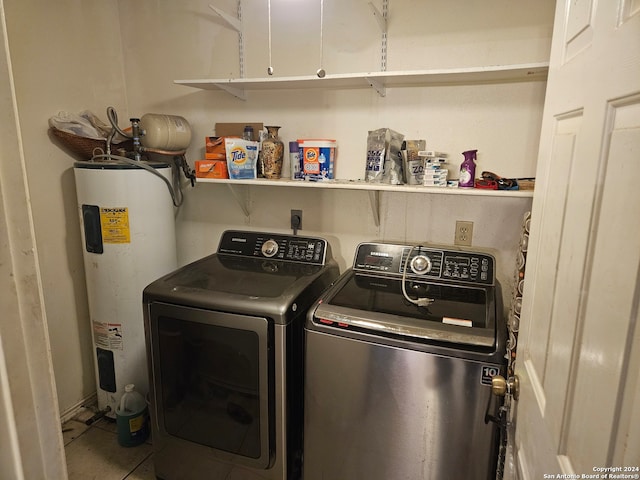 clothes washing area featuring cabinets, independent washer and dryer, and electric water heater