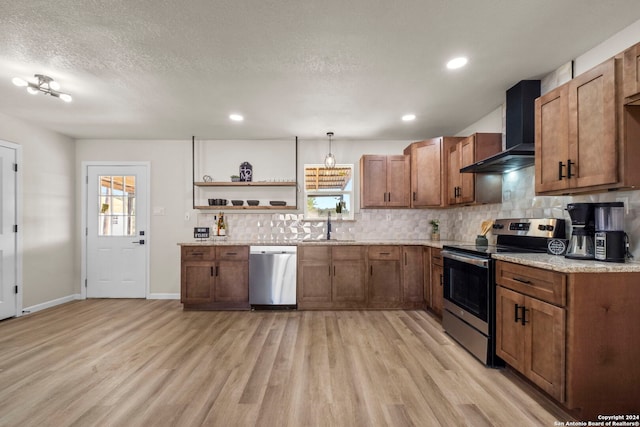 kitchen with appliances with stainless steel finishes, light hardwood / wood-style floors, plenty of natural light, and wall chimney exhaust hood