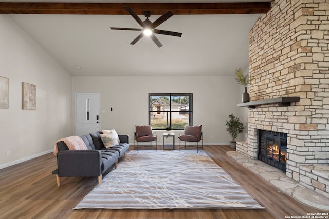 living room featuring beamed ceiling, wood-type flooring, a fireplace, and ceiling fan