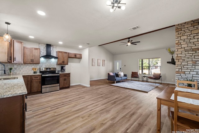 kitchen with pendant lighting, electric stove, wall chimney range hood, vaulted ceiling, and light wood-type flooring