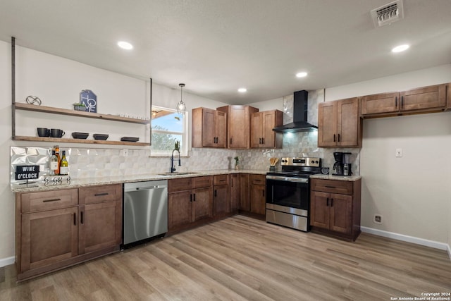 kitchen with sink, wall chimney exhaust hood, stainless steel appliances, and light wood-type flooring