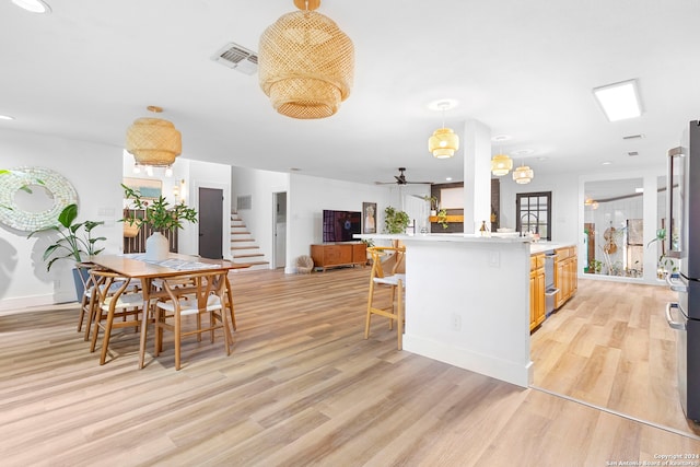 kitchen featuring decorative light fixtures, light brown cabinets, light hardwood / wood-style floors, and ceiling fan