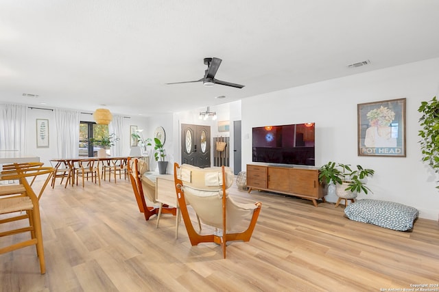 living room featuring light hardwood / wood-style floors and ceiling fan