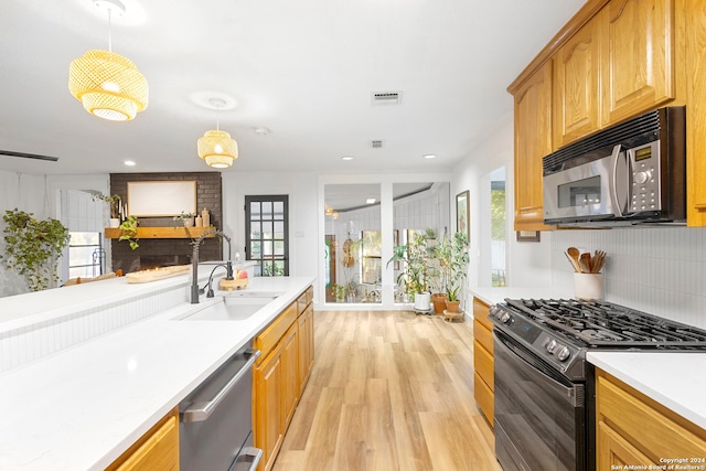 kitchen with a healthy amount of sunlight, pendant lighting, black appliances, and sink