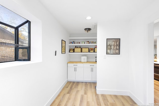 bar featuring white cabinets and light wood-type flooring