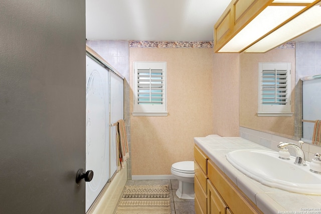 full bathroom with shower / bath combination with glass door, vanity, tile patterned floors, and toilet