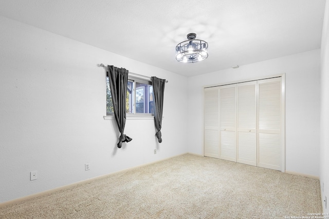 unfurnished bedroom featuring carpet flooring and a closet