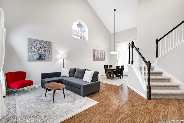 living room featuring wood-type flooring and high vaulted ceiling