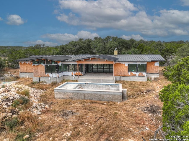 1722 Paradise Pkwy, Canyon Lake, TX 78133 - back of house with a standing seam roof, metal roof, a chimney, and a view of trees