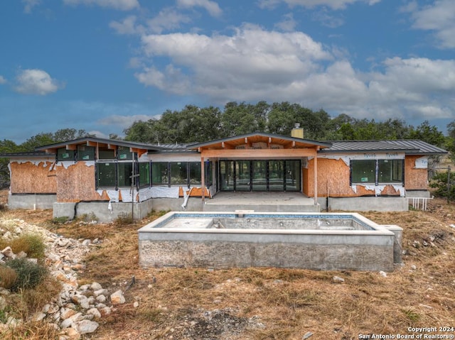 1722 Paradise Pkwy, Canyon Lake, TX 78133 - back of property with metal roof, an empty pool, a standing seam roof, a patio area, and a chimney