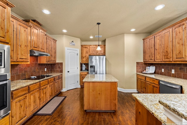 kitchen featuring a center island, light stone countertops, dark wood-type flooring, and appliances with stainless steel finishes