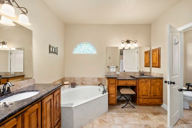 bathroom with vanity, toilet, and a tub