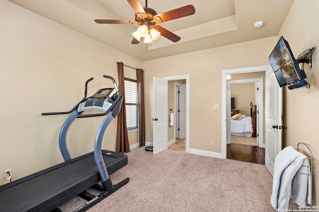 workout room with ceiling fan and light colored carpet