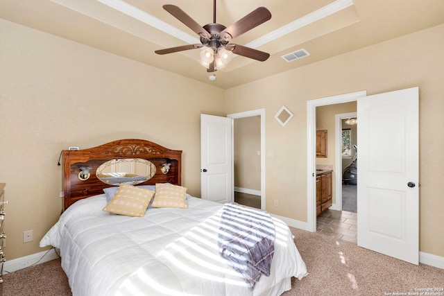 carpeted bedroom with connected bathroom, a raised ceiling, and ceiling fan