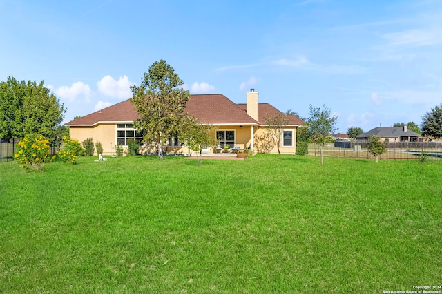 rear view of house featuring a yard and a patio area