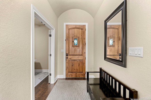 foyer with dark hardwood / wood-style flooring and lofted ceiling