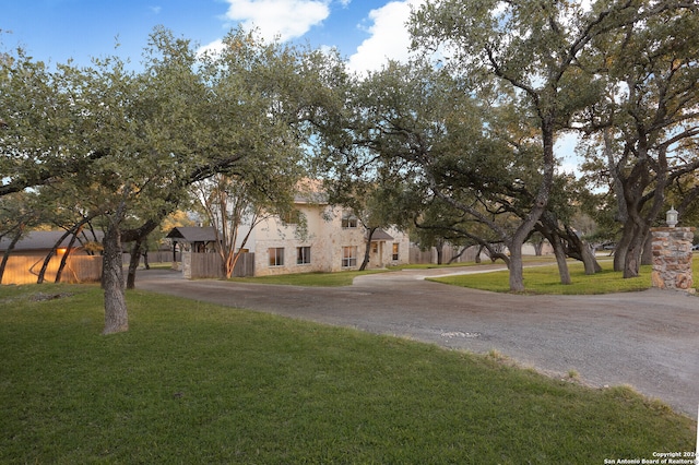 view of property hidden behind natural elements featuring a front yard