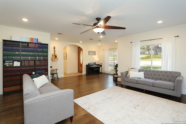 living room with ceiling fan and dark wood-type flooring