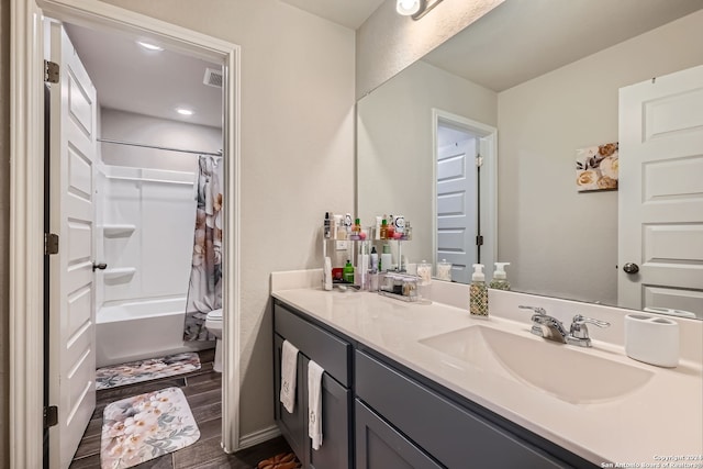 full bathroom featuring shower / bath combo with shower curtain, hardwood / wood-style floors, vanity, and toilet