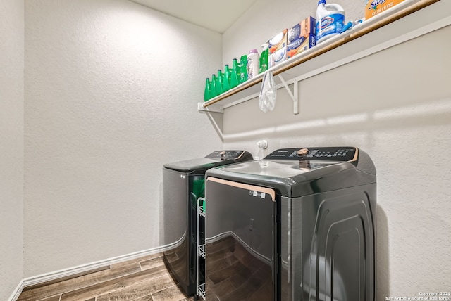 laundry area with hardwood / wood-style flooring and independent washer and dryer