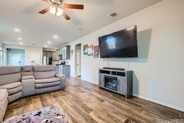 living room with ceiling fan and hardwood / wood-style floors