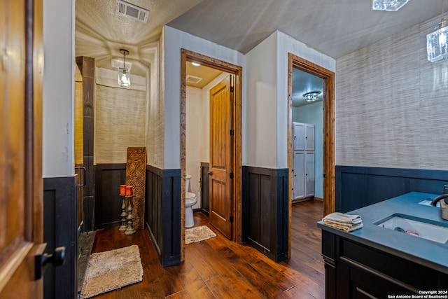 corridor with wood walls, dark hardwood / wood-style flooring, and sink