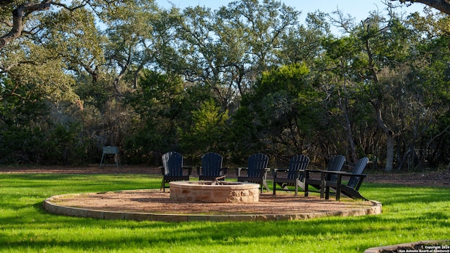 view of community with a lawn and a fire pit