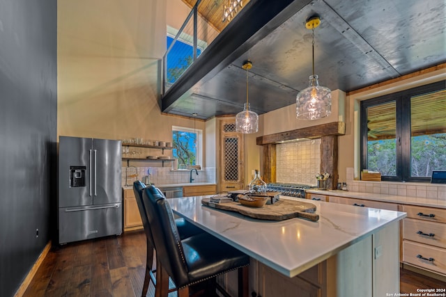 kitchen featuring decorative backsplash, appliances with stainless steel finishes, a center island, and decorative light fixtures