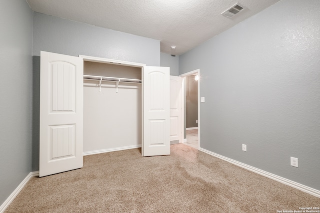 unfurnished bedroom featuring carpet, a textured ceiling, and a closet