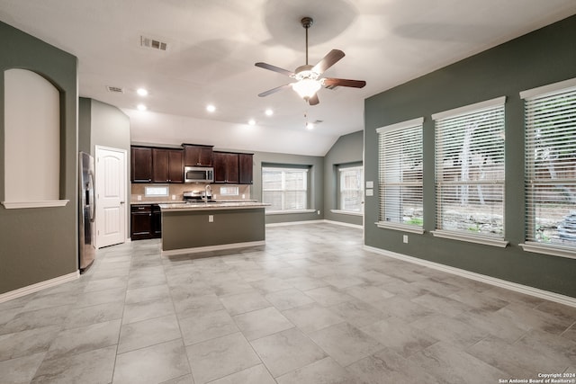 kitchen featuring ceiling fan, sink, stainless steel appliances, an island with sink, and vaulted ceiling