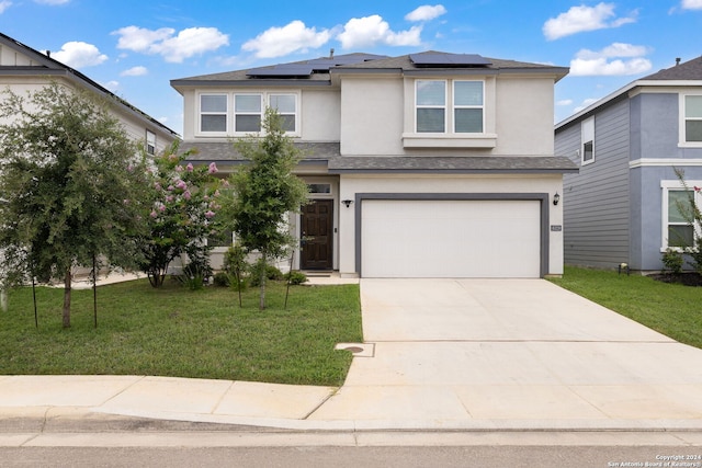 view of front of home with a front yard and a garage