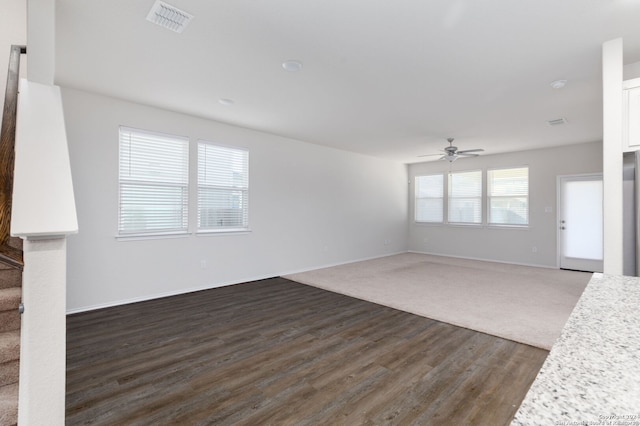 unfurnished living room featuring ceiling fan and dark wood-type flooring