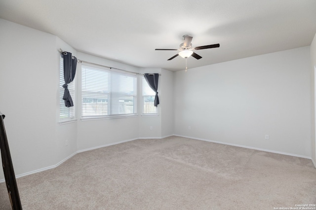 unfurnished room with ceiling fan and light carpet