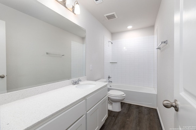 full bathroom with hardwood / wood-style floors, vanity, toilet, and tiled shower / bath