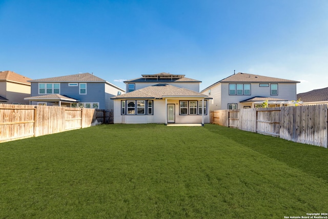 rear view of house featuring a lawn