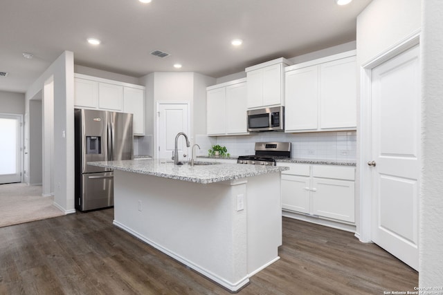 kitchen with stainless steel appliances, white cabinetry, a center island with sink, and sink