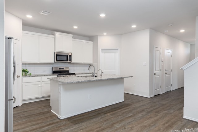 kitchen with sink, stainless steel appliances, dark hardwood / wood-style floors, and an island with sink