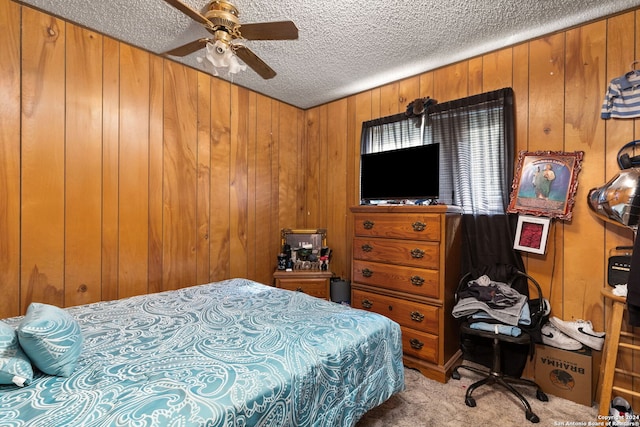 bedroom with ceiling fan, wooden walls, and a textured ceiling