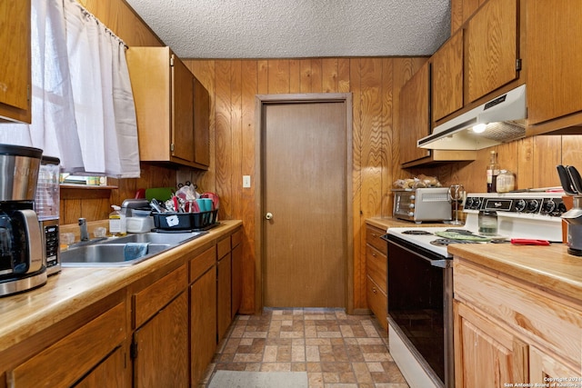 kitchen featuring a textured ceiling, wood walls, sink, and white electric stove