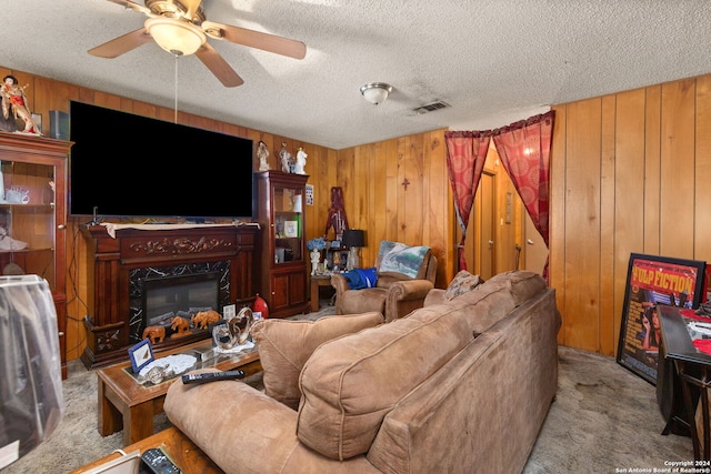 living room with a high end fireplace, a textured ceiling, light colored carpet, and wooden walls