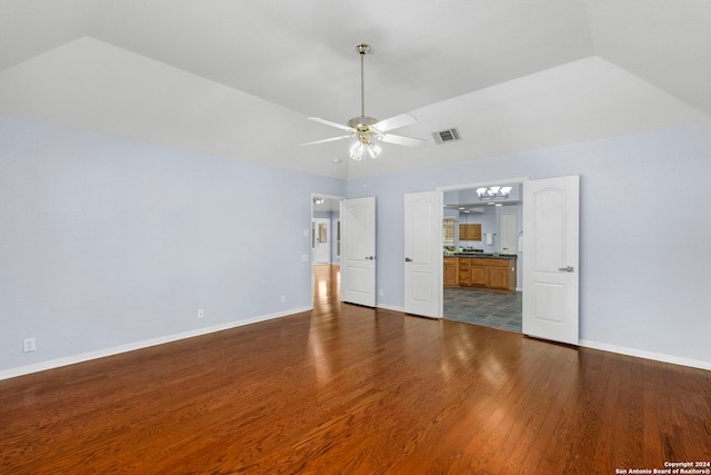 unfurnished living room featuring lofted ceiling, wood-type flooring, and ceiling fan with notable chandelier