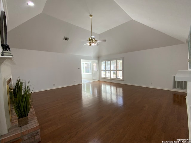 unfurnished living room with dark wood-type flooring, a brick fireplace, ceiling fan, and lofted ceiling