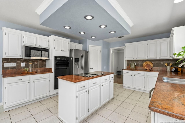 kitchen with black appliances, white cabinets, and sink