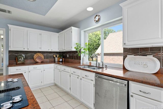 kitchen featuring stainless steel dishwasher, white cabinetry, sink, and light tile patterned floors